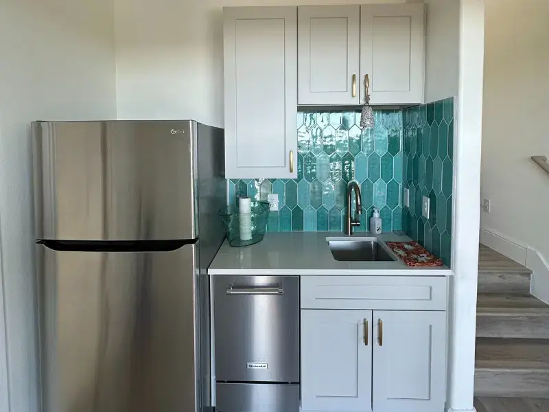 Compact kitchen space with teal backsplash in El Cielo Whole Home Remodel, Austin TX