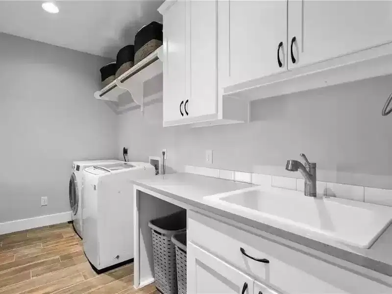 Modern laundry room with white cabinets and sink in Austin, TX