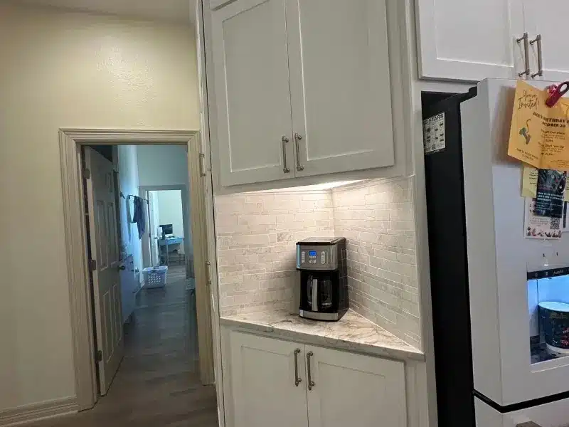 Kitchen coffee nook with white cabinets, espresso maker, and marble counter in Austin, TX home<br />
