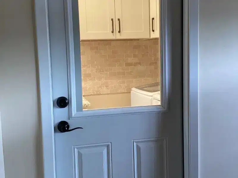 Laundry room view through door with cabinets and washer in Austin, TX home<br />
